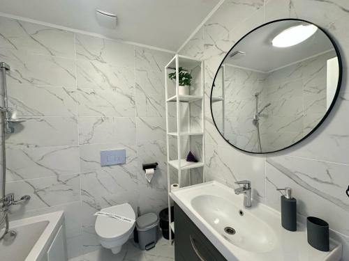 a white bathroom with a sink and a mirror at Cosmopolis - Anturium Studio in Gara Pantelimon