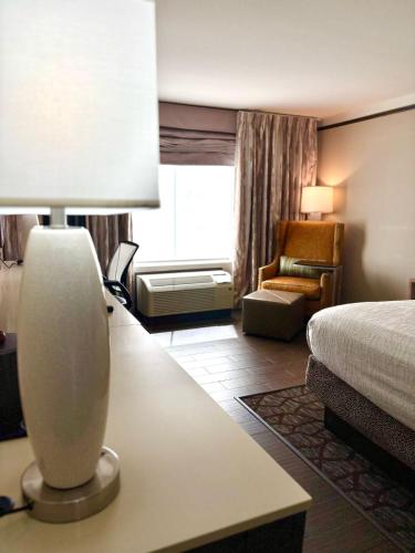 a hotel room with a bed and a table with a lamp at Kozy Hotel Houston North in Westfield