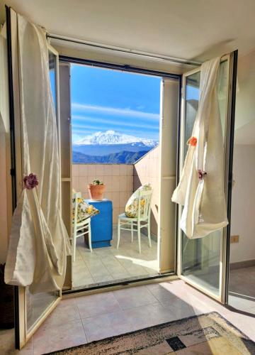 a sliding glass door with a view of a mountain at Vista Alcantara - Wellness Mountain-Top Retreat in Motta Camastra