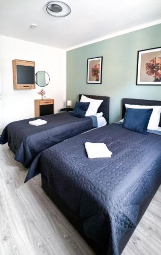 a bedroom with two beds with blue comforters at 2 ZKB-3OG oder 3 ZKB-UG im Zentrum zw Rathaus und Dom in Augsburg
