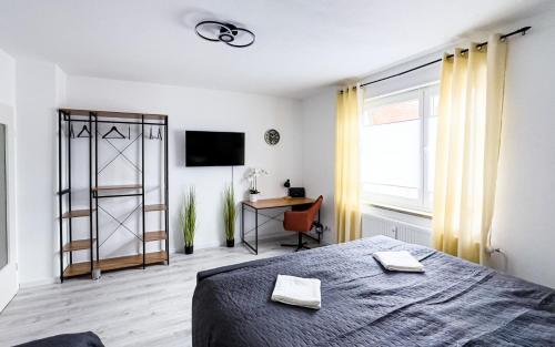 a bedroom with a bed and a desk and a window at 2 ZKB-3OG oder 3 ZKB-UG im Zentrum zw Rathaus und Dom in Augsburg