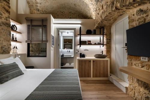 a bedroom with a large bed and a bathroom at YeeOn Living-Well Boutique City Hotel Gythio in Gythio