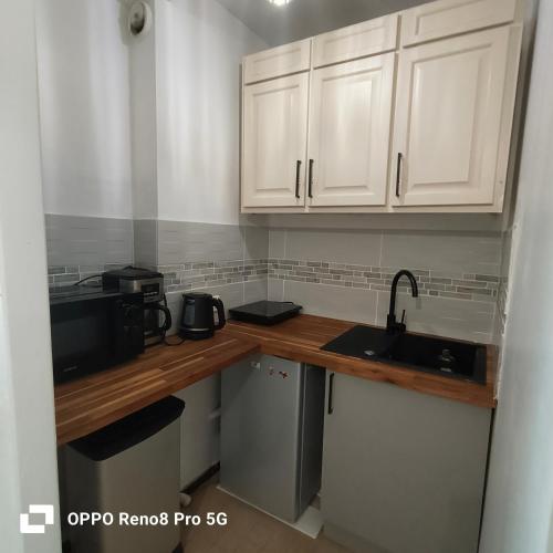 une cuisine avec des armoires blanches et un évier dans l'établissement COSY studio, à Marseille