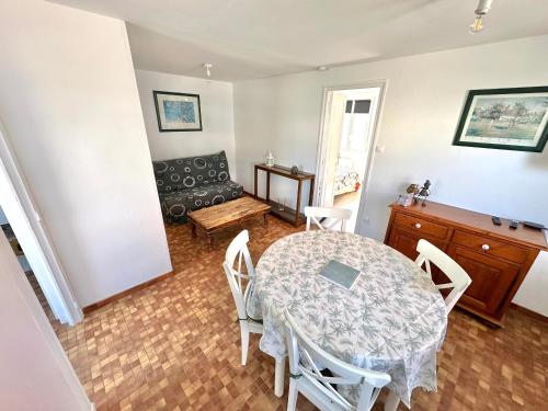 una sala de estar con una mesa y un sofá en Maisonnette de vacances paisible à Berck-Plage, en Berck-sur-Mer