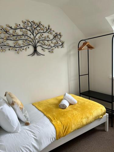 a bedroom with a bed with a tree on the wall at Olive Lodge in Southampton