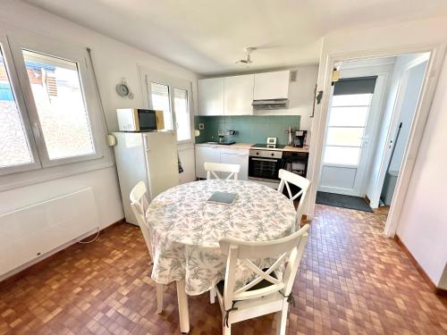 Una cocina y un comedor con mesa y sillas. en Maisonnette de vacances paisible à Berck-Plage, en Berck-sur-Mer