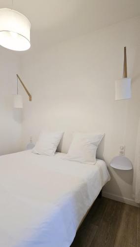 - un lit blanc avec des oreillers blancs dans l'établissement Catel Studio hyper centre Saint Dizier, à Saint-Dizier