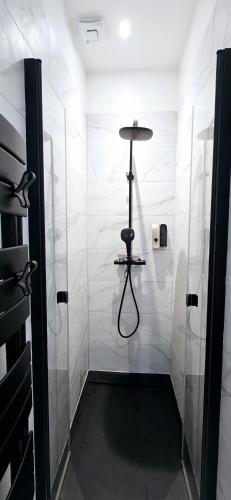 La salle de bains est pourvue de murs carrelés blancs et d'une cabine de douche. dans l'établissement Catel Studio hyper centre Saint Dizier, à Saint-Dizier