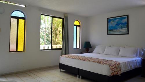 a bedroom with a bed and two windows at Amanwana Ecofinca in Melgar