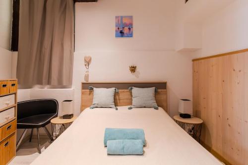une chambre avec un lit avec un oreiller bleu dessus dans l'établissement Apparemment charmant au cœur du Suquet, à Cannes