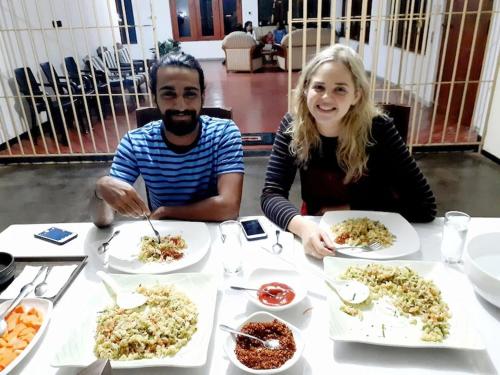 a man and woman sitting at a table with plates of food at Raa Pala Lake Resort in Anuradhapura