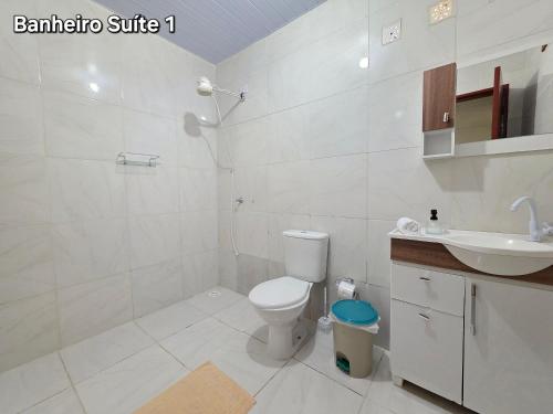 biała łazienka z toaletą i umywalką w obiekcie Casa 3 suítes 5km das Cataratas w Foz do Iguaçu