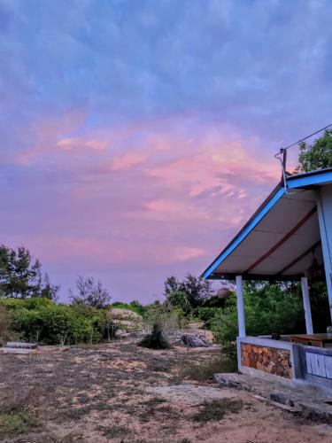 a building with a blue roof in a field at Garnet Yala Beach in Kirinda
