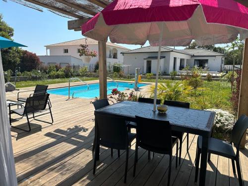 un patio avec une table, des chaises et un parasol dans l'établissement Villa avec piscine privée Santa Maria Poggio, à Santa-Maria-Poggio
