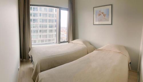 2 lits dans une chambre d'hôpital avec fenêtre dans l'établissement Spacious corner apartment with sea view, à Helsinki