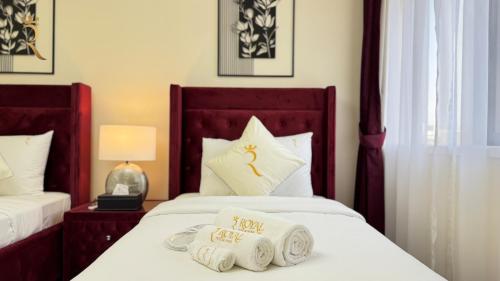 a hotel room with two beds with towels on them at Al Raha 4BR Oasis Elegant Luxury Retreat in Abu Dhabi