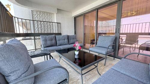 a room with chairs and a table and a balcony at Al Raha 4BR Oasis Elegant Luxury Retreat in Abu Dhabi