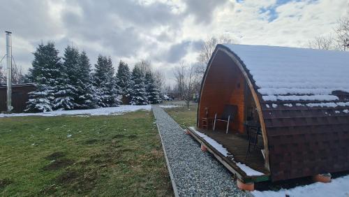 a small cabin with a snow covered roof at Căsuțe în mijlocul naturii - Wild Camp Avrig in Avrig