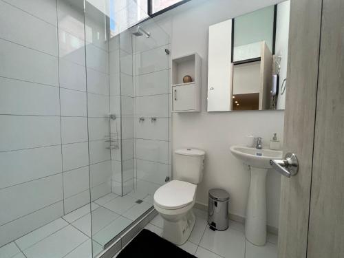 a white bathroom with a toilet and a sink at Ope Suites calle 100 in Bogotá
