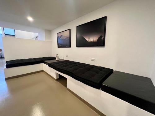 a living room with a black couch against a wall at Ope Suites calle 100 in Bogotá