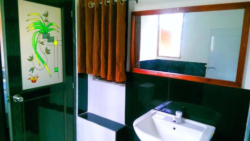 a bathroom with a sink and a mirror at Pelican View Cottages in Kataragama