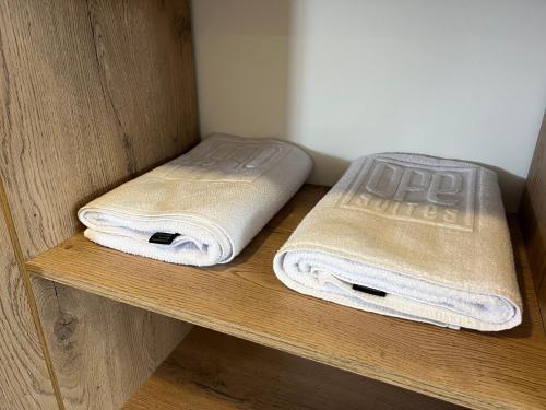 two towels are sitting on a wooden shelf at Ope Suites calle 100 in Bogotá