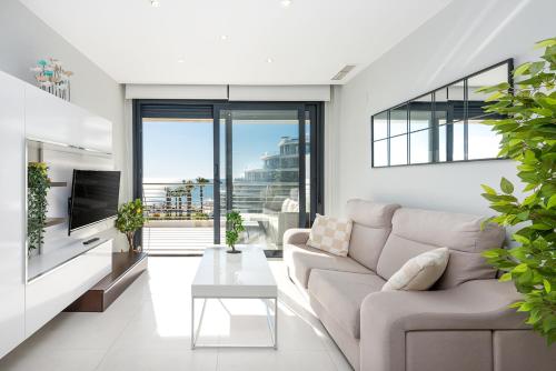 a living room with a couch and a table at Luxury Seaview Beachfront Apartment Pools,Jacuzzi,Gym in Arenales del Sol