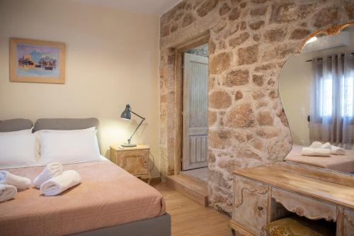 a bedroom with two beds and a stone wall at Gravel Aegina House in Aegina