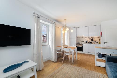a living room with a table and a kitchen at Modern Lisbon Apartments by Soulplaces in Lisbon
