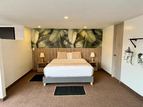 a bedroom with a bed and a mural of leaves at Ope Suites calle 100 in Bogotá