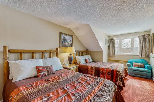 a hotel room with two beds and a chair at Mountainview at Rivergreen in Lincoln