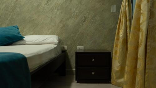 a small bedroom with a bed and a night stand at Rest in Urabá - Descanso perfecto en Urabá in Carepa