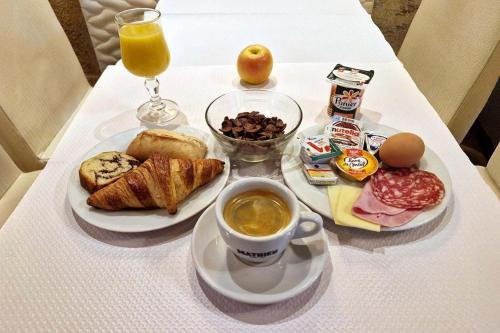 a table with a plate of breakfast food and a cup of coffee at Hôtel du Mont Blanc in Paris