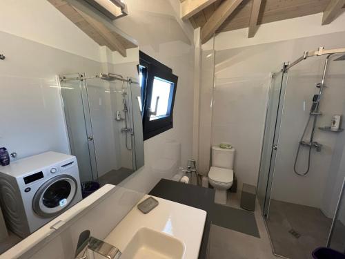 a bathroom with a shower and a washing machine at Arachova Villa Paris in Kalívia