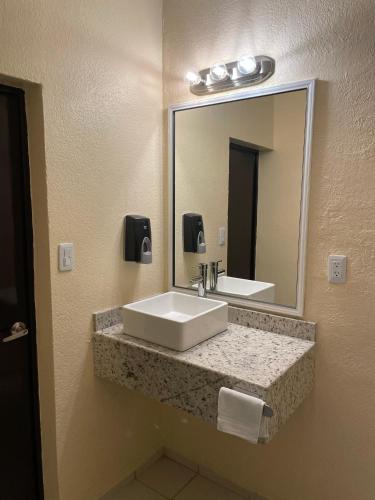 a bathroom with a sink and a mirror at Motel Apolo 69 in Santa Ana