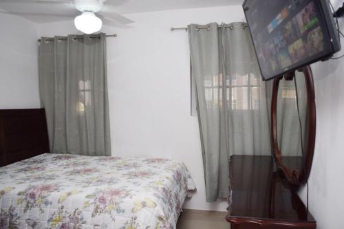 a bedroom with a bed and a flat screen tv at Relax in this apartment in Santiago de los Caballeros