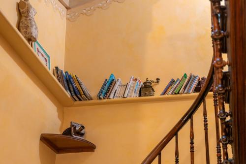 a staircase with a shelf filled with books at Hôtel Le Bois Joli in Cauterets