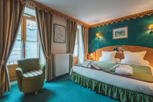 a hotel room with a bed and a chair at Hôtel Le Bois Joli in Cauterets