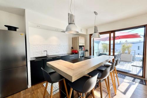 une cuisine avec une table en bois et quelques chaises dans l'établissement Magnifique maison d’architecte - Plages à pied, à Larmor-Plage