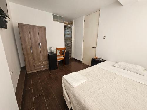 a bedroom with a bed and a wooden door at Hospedaje Pimentel in Pimentel