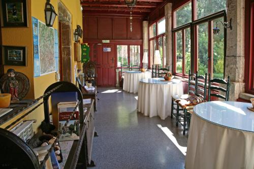 una fila de mesas en una habitación con mesas blancas en Hotel y AR Palacio Flórez Estrada, en Pola de Somiedo