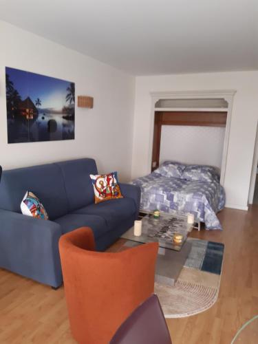 - un salon avec un canapé bleu et un lit dans l'établissement SPACIEUX STUDIO 37m2 - Terrasse VUE MER, à Cannes