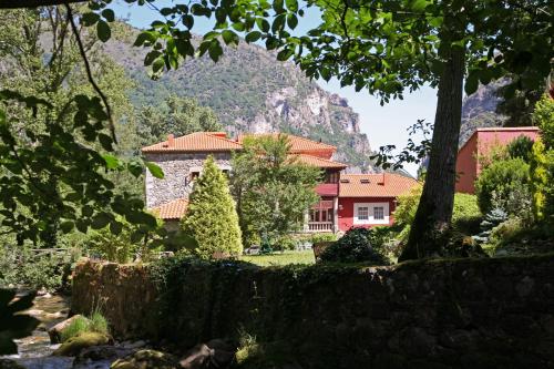 a house with a mountain in the background at Hotel y AR Palacio Flórez Estrada in Pola de Somiedo