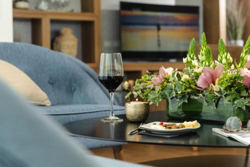a glass of wine and a plate of food on a table at Hotel Rothschild 22 in Tel Aviv