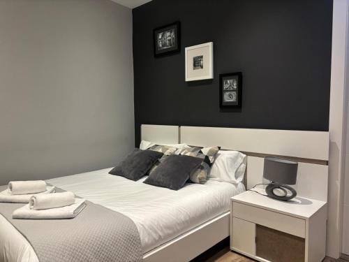 a bedroom with a white bed with a black wall at maitagarri casco antiguo in Pamplona