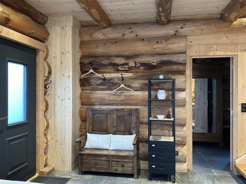 a room with a wooden wall with a bench and a shelf at Auvergne, Chalet cinq étoiles en fuste, 6 personnes avec spa, campagne et chevaux in Saint-Jean-en-Val