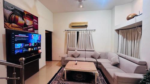 a living room with a couch and a flat screen tv at Golden Sun ray beach villa in Saligao