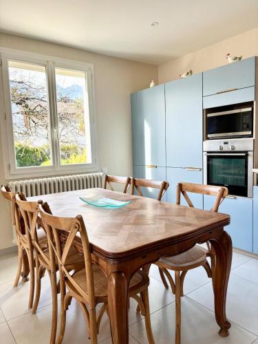 - une cuisine avec une table à manger en bois et des chaises dans l'établissement Lovely apartment in Albertville, à Albertville