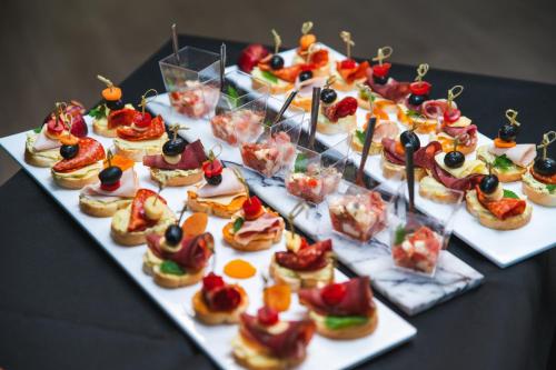 a table with a bunch of appetizers on plates at voco - Podgorica by IHG in Podgorica