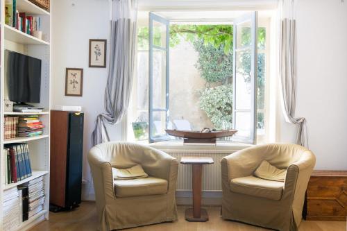 - un salon avec deux chaises et une fenêtre dans l'établissement Grande Maison de famille patio, babyfoot, vélos, wifi, à Marennes